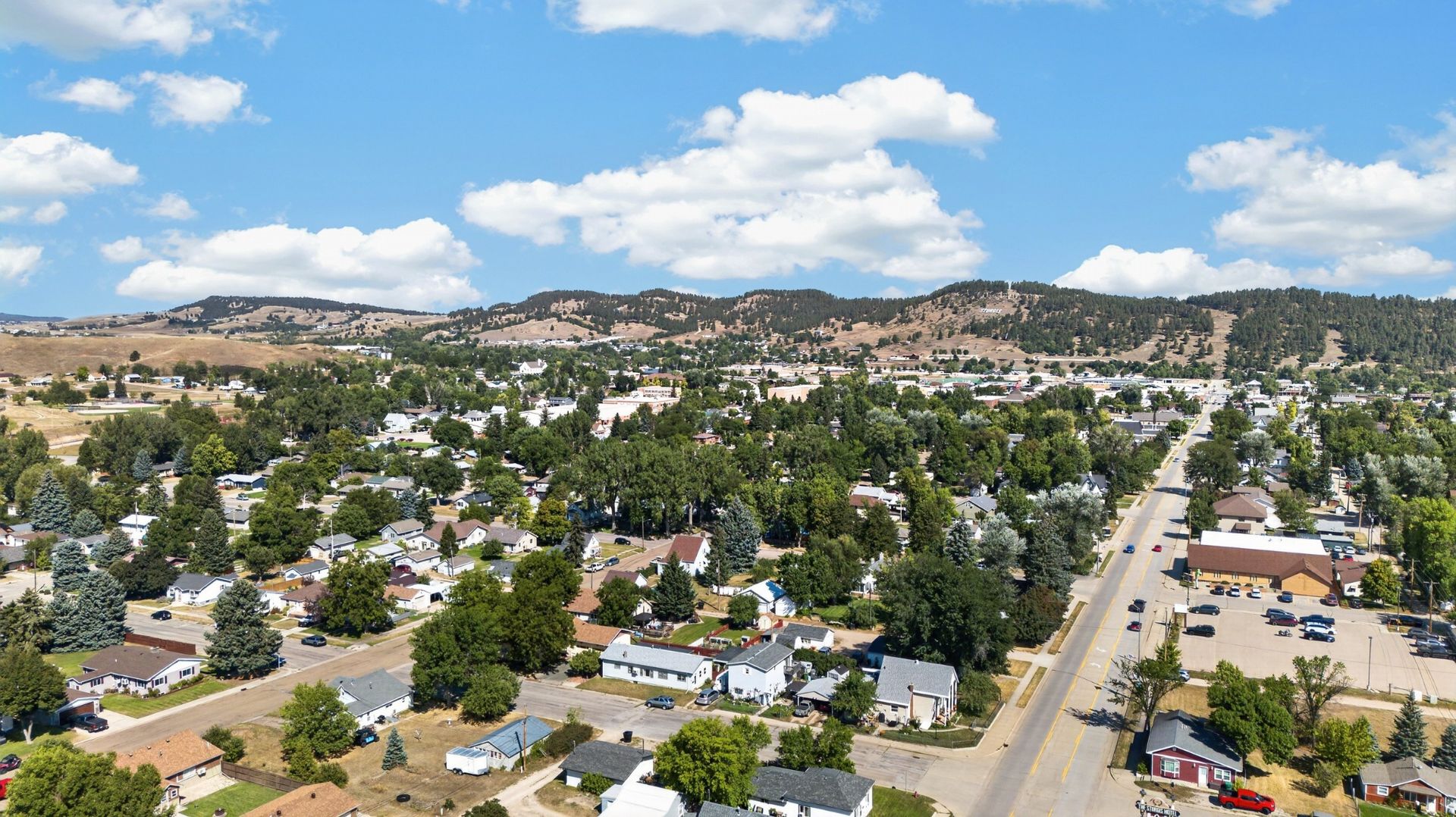Aerial view of Sturgis, South Dakota, showing established neighborhoods, downtown streets and the surrounding Black Hills.